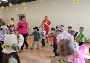Dzieci tańczą z nauczycielami po kole.