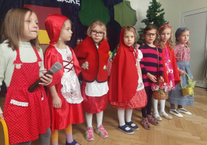 7 dziewczynek przebranych za Czerwone Kapturki, w strojach charakterystycznych dla tej postaci.