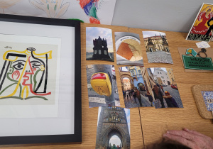 Eksponaty przywiezione z Włoch (breloki), Madery (podkładka) Obraz -replika Pablo Picasso, zdjęcia z Pragi oraz widokówka z hiszpani.