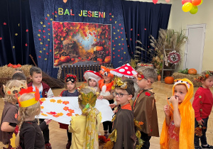 Dzieci stoją i trzymają w rękach ozdobiony plakat.