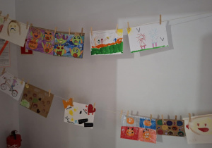 Na dwóch sznurkach przymocowane są prace dzieci n.t relacji i emocji