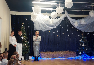 Na scenie stoją od lewej prowadzące: Pani Irmina, pani Justyna oraz pani wicedyrektor, która mówi przez mikrofon.