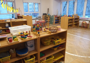 Klasa przedszkolna -po prawej i lewej stronie znajdują się szafki z półkami na których w koszykach znajdują się pomoce rozwojowe.